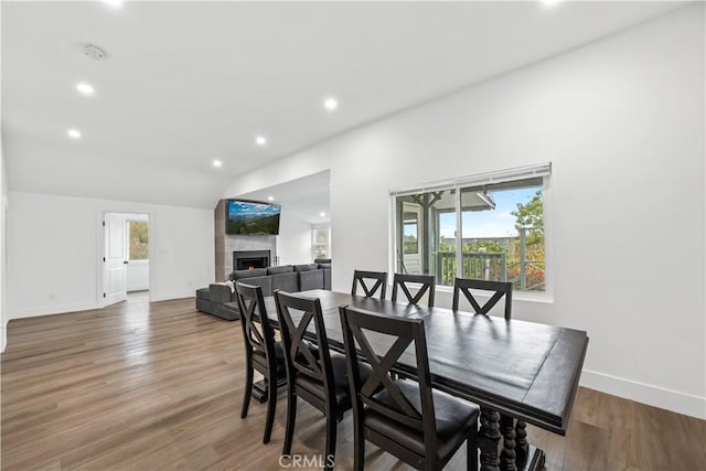 310 Whittley Ave Unit A, Avalon, CA 90704 - dining space with a wealth of natural light, a lit fireplace, wood finished floors, and lofted ceiling