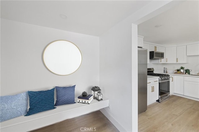 310 Whittley Ave Unit A, Avalon, CA 90704 - interior space with light countertops, white cabinetry, light wood-style flooring, stainless steel appliances, and baseboards