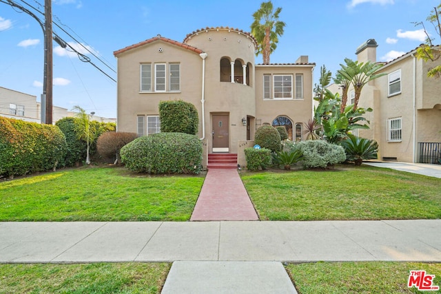 mediterranean / spanish house with a front yard