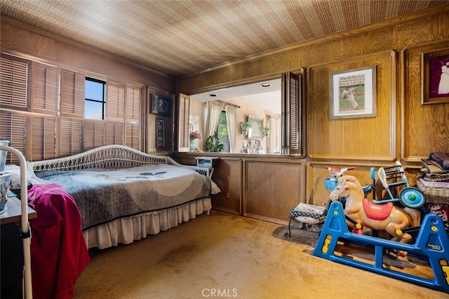 carpeted bedroom featuring wood walls