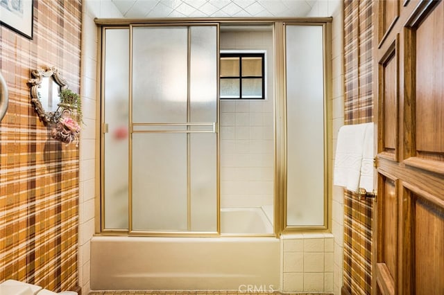 bathroom featuring tile walls and enclosed tub / shower combo