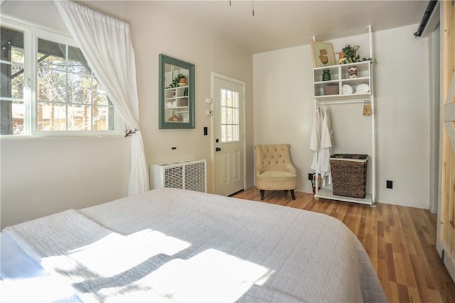 bedroom with hardwood / wood-style flooring and radiator heating unit