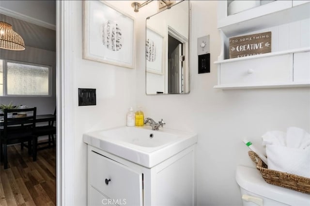 bathroom featuring toilet, hardwood / wood-style floors, and vanity