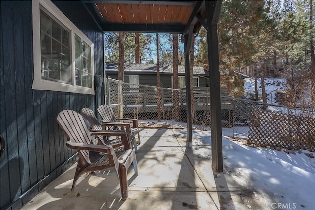 snow covered patio featuring a deck