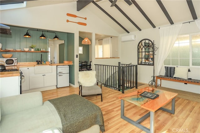 living room featuring sink, light wood-type flooring, an AC wall unit, beamed ceiling, and high vaulted ceiling