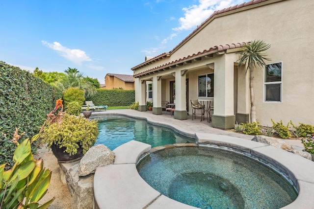 view of swimming pool with a patio area and an in ground hot tub