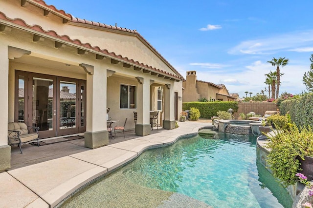 view of pool featuring an in ground hot tub, a patio, and french doors