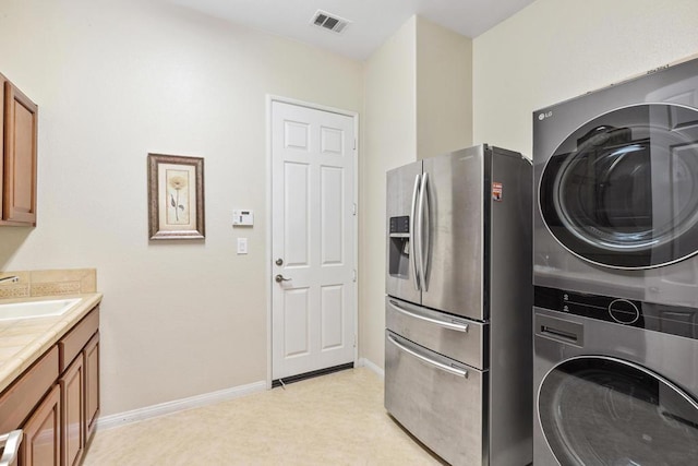 laundry room featuring sink and stacked washing maching and dryer