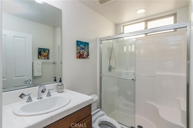 bathroom featuring vanity, an enclosed shower, and toilet