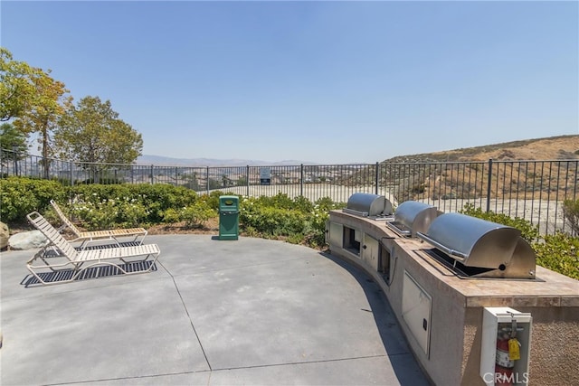 view of patio / terrace with a mountain view, area for grilling, and a grill