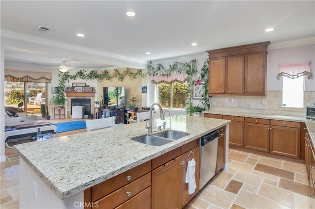 kitchen featuring plenty of natural light, dishwasher, sink, and an island with sink