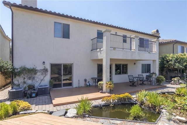 rear view of property featuring a wooden deck, a balcony, and central AC unit