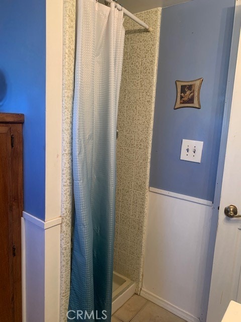 bathroom featuring curtained shower and tile patterned flooring