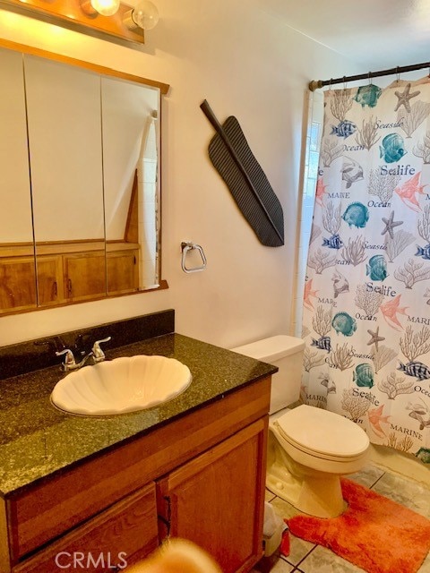 bathroom with toilet, tile patterned flooring, a shower with shower curtain, and vanity