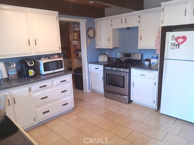 kitchen featuring white cabinetry, dark countertops, and white appliances