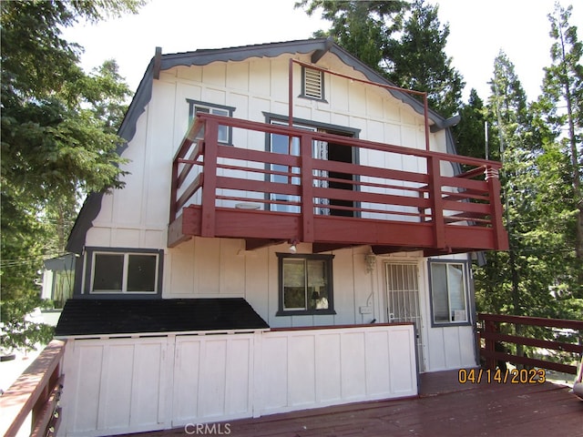 rear view of property featuring a wooden deck