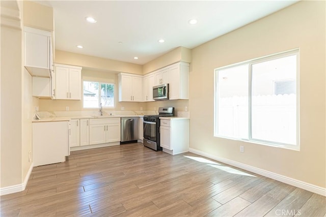 9246 Cedros Ave Unit 1, Panorama City, CA 91402 - kitchen with appliances with stainless steel finishes, light wood-style flooring, light countertops, white cabinetry, and recessed lighting