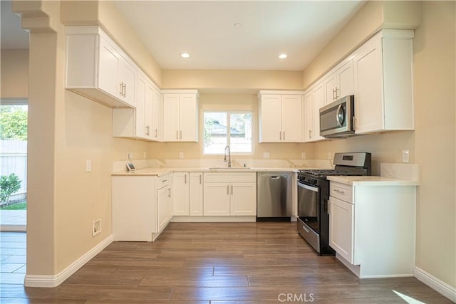 9246 Cedros Ave Unit 1, Panorama City, CA 91402 - kitchen with appliances with stainless steel finishes, dark wood finished floors, healthy amount of natural light, white cabinets, and recessed lighting