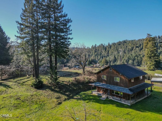 rear view of property featuring a lawn