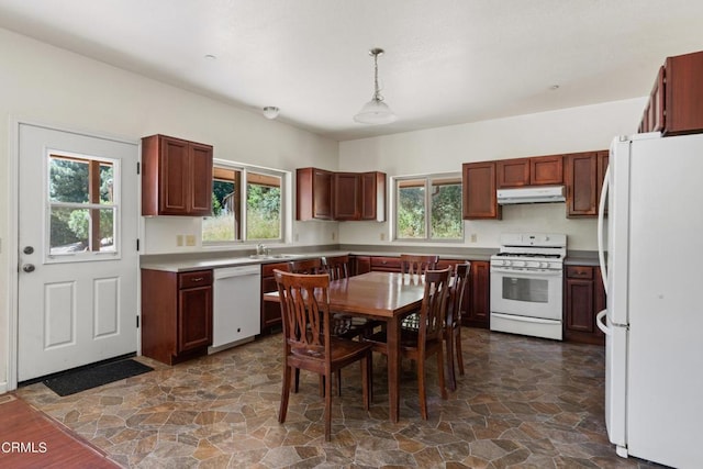 kitchen featuring sink, pendant lighting, and white appliances