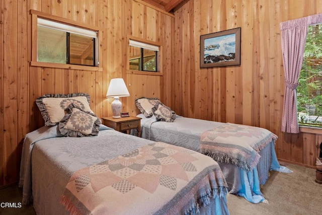 carpeted bedroom featuring wood walls