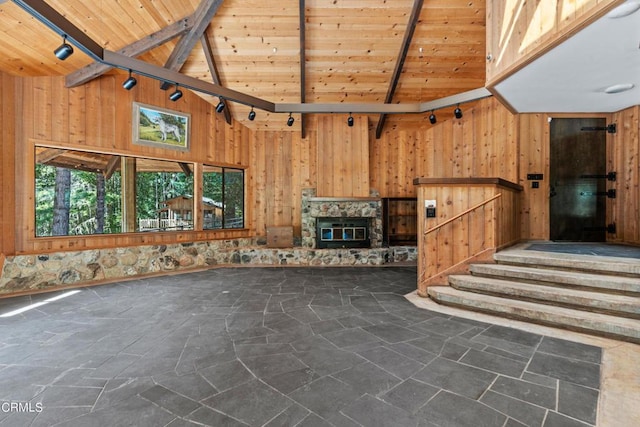 unfurnished living room featuring wooden ceiling, beam ceiling, and wood walls