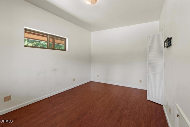 unfurnished room with dark wood-type flooring