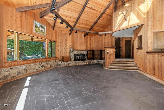 unfurnished living room featuring beamed ceiling, wooden ceiling, and wood walls