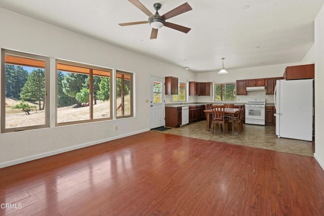 kitchen with a kitchen island, dark hardwood / wood-style floors, pendant lighting, and white appliances