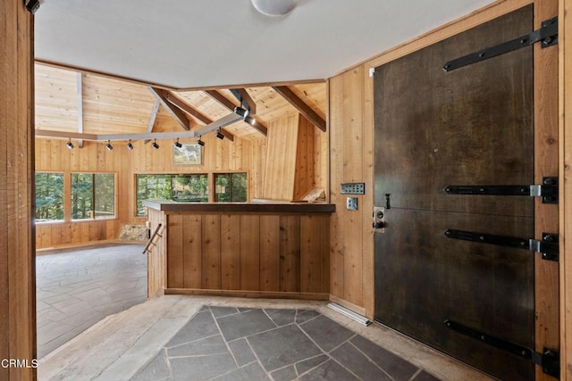 interior space featuring vaulted ceiling with beams, wooden ceiling, and wooden walls