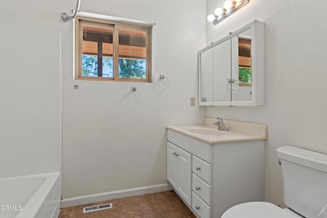 bathroom featuring vanity, toilet, a wealth of natural light, and a washtub