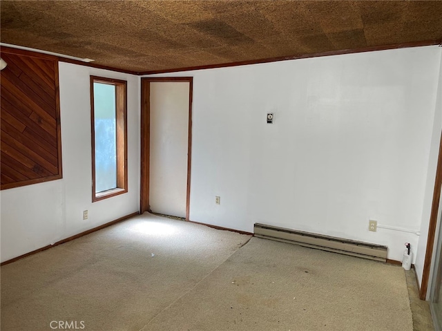 carpeted spare room with baseboard heating and crown molding