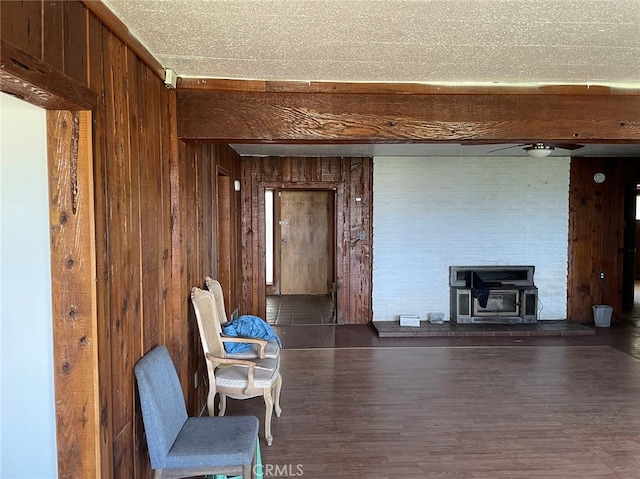 interior space featuring a wood stove, wooden walls, and dark hardwood / wood-style floors