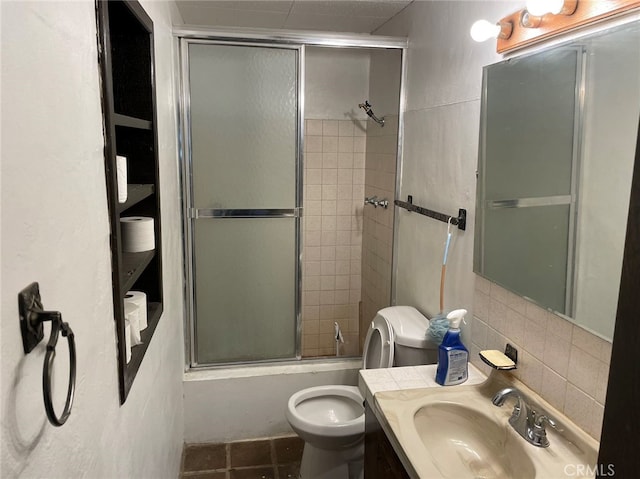 full bathroom with tasteful backsplash, combined bath / shower with glass door, toilet, vanity, and tile patterned flooring