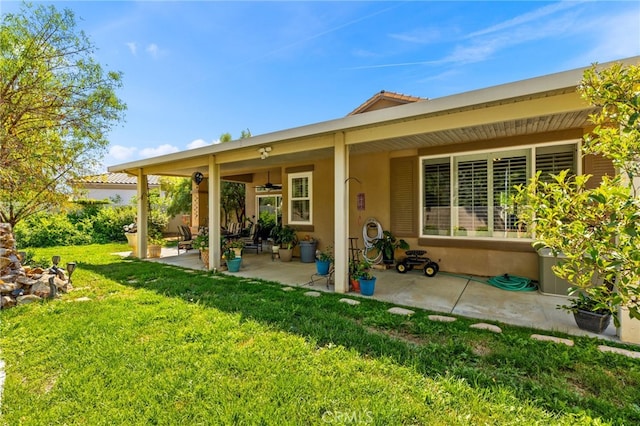 rear view of house featuring a lawn and a patio area