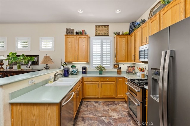 kitchen featuring kitchen peninsula, sink, and appliances with stainless steel finishes