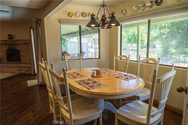 dining space featuring dark wood-type flooring and a notable chandelier