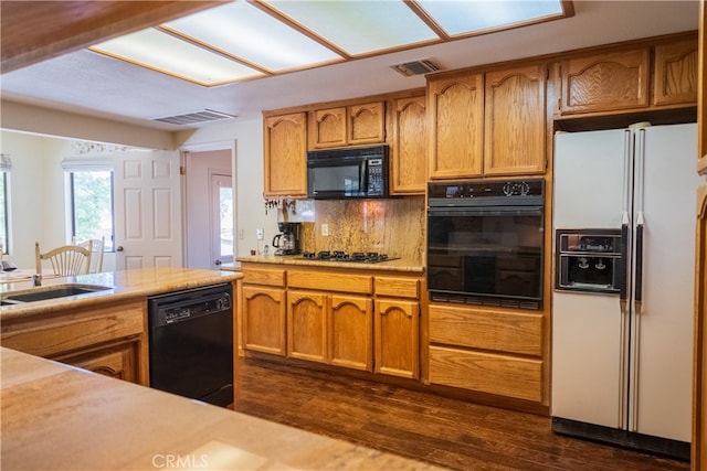 kitchen with black appliances, tasteful backsplash, sink, and dark wood-type flooring