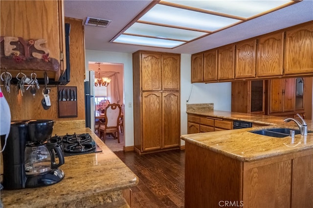 kitchen with kitchen peninsula, light stone countertops, dark wood-type flooring, sink, and a notable chandelier