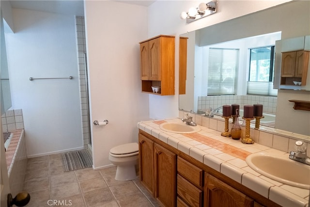 bathroom featuring tile patterned flooring, vanity, a bath, and toilet