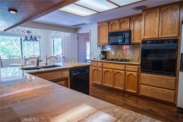 kitchen with sink, black appliances, pendant lighting, a notable chandelier, and dark hardwood / wood-style floors