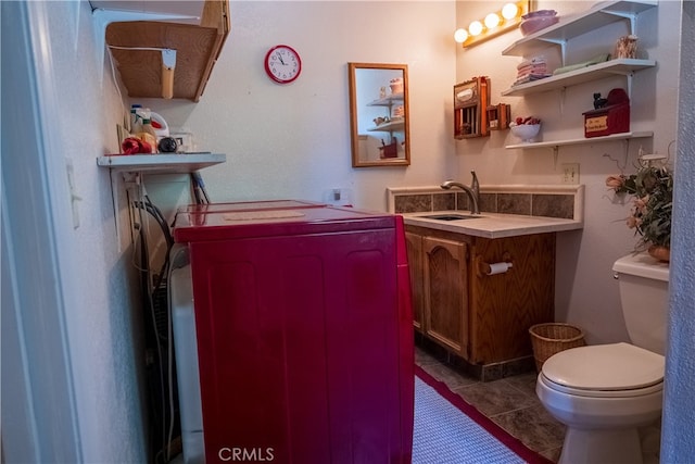 interior space featuring tile patterned floors, vanity, toilet, and independent washer and dryer