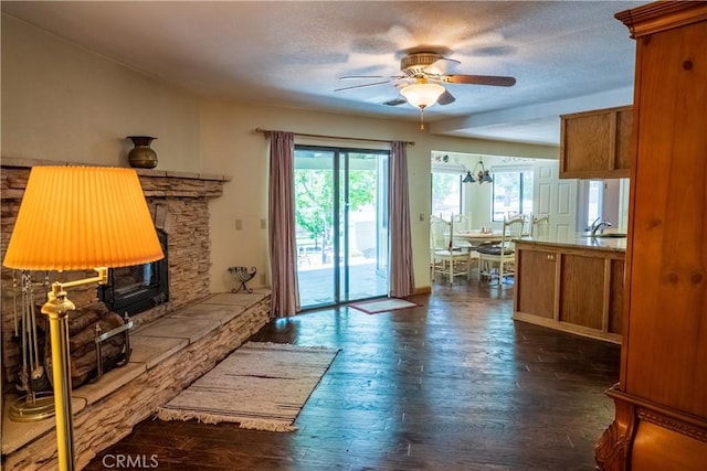 living room featuring a textured ceiling, ceiling fan with notable chandelier, dark hardwood / wood-style floors, and sink