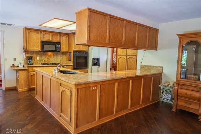 kitchen with kitchen peninsula, dark hardwood / wood-style flooring, sink, and black appliances