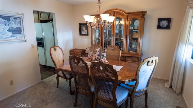 carpeted dining area with an inviting chandelier