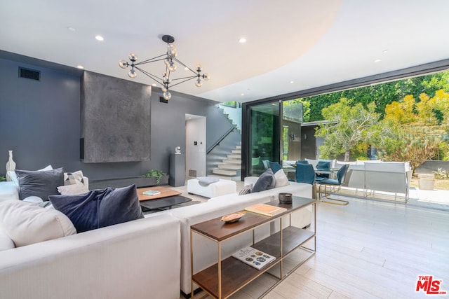 living room with light hardwood / wood-style floors and an inviting chandelier