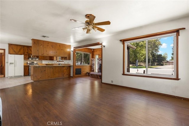 unfurnished living room with ceiling fan, a wealth of natural light, and wood finished floors