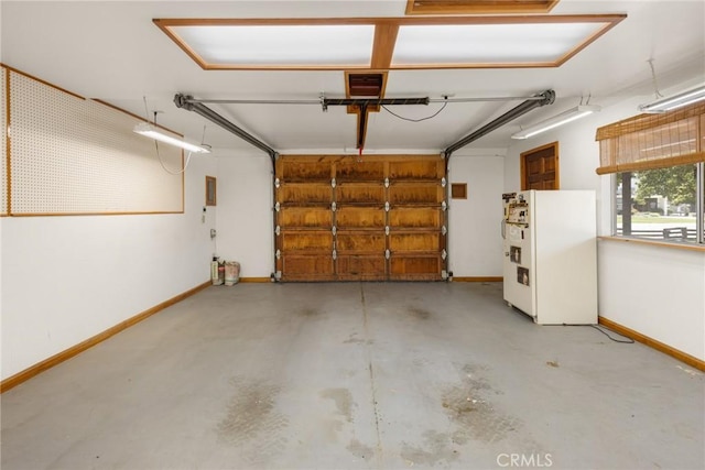 garage with freestanding refrigerator and baseboards