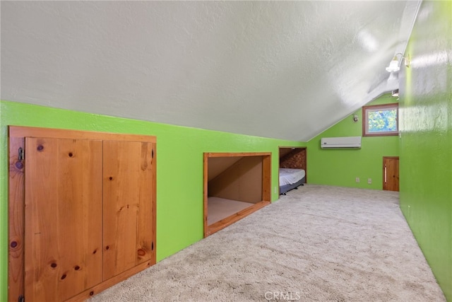 additional living space featuring a textured ceiling, carpet, vaulted ceiling, and an AC wall unit