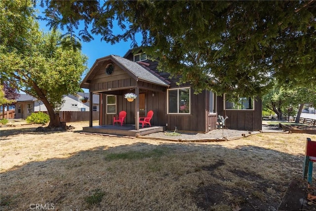 bungalow-style home with board and batten siding, fence, and a wooden deck